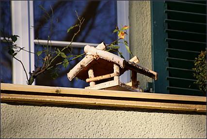 Ein kleines Vogelhaus auf einem Balkon