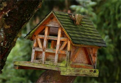 Ein verwittertes altes Vogelhaus in Fachwerk-Bauweise.